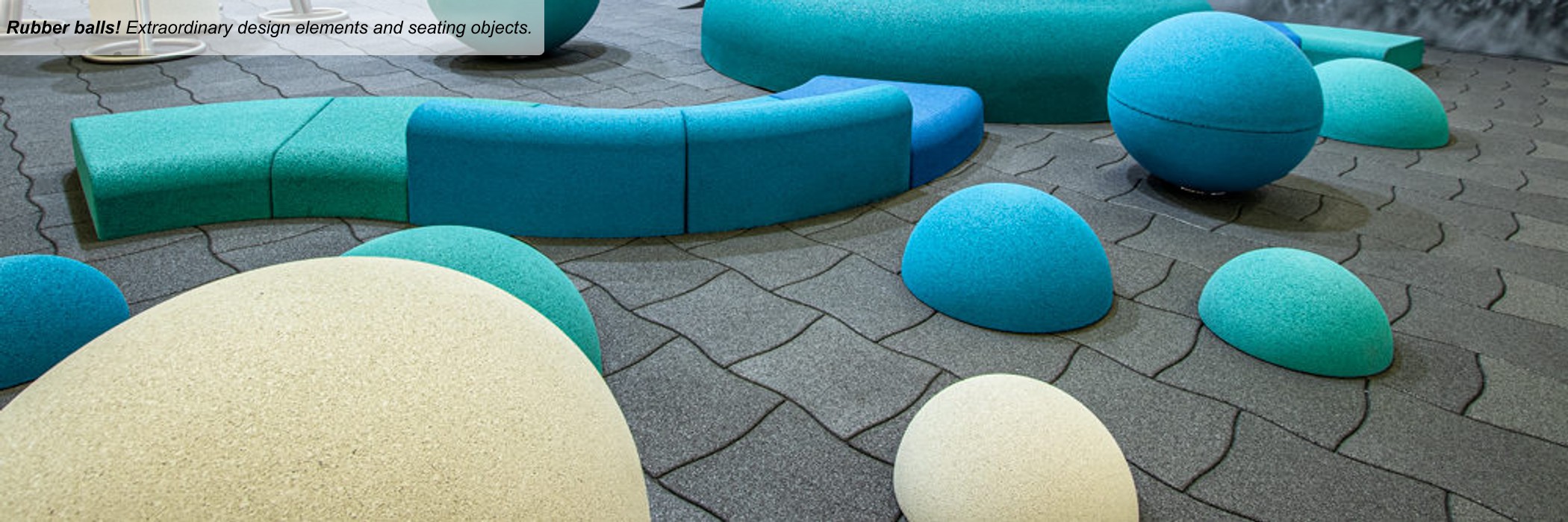 Blue, gray and yellow balls and half balls of rubber on a black flooring